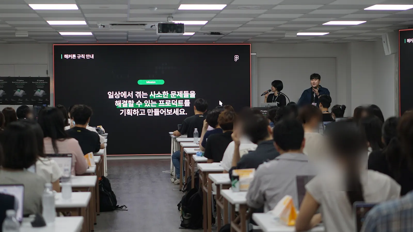 해커톤 미션을 안내하는 화면 앞에서 참가자들에게 진행 방식을 설명하는 모습